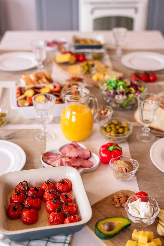 A colorful brunch table featuring fresh produce, meats, and juices, perfect for a lively gathering.