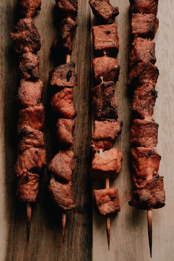 Appetizing grilled beef skewers arranged on a rustic wooden board, perfect for a BBQ theme.