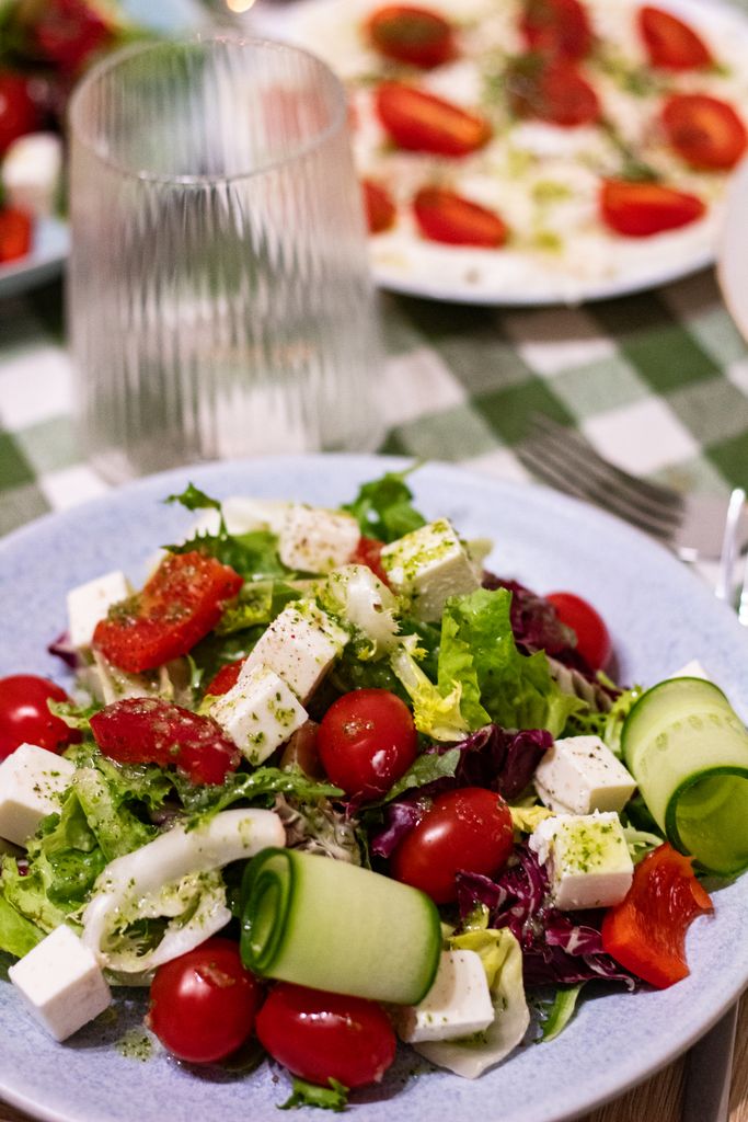 Delicious Greek salad featuring feta cheese, cherry tomatoes, cucumbers, and mixed greens.