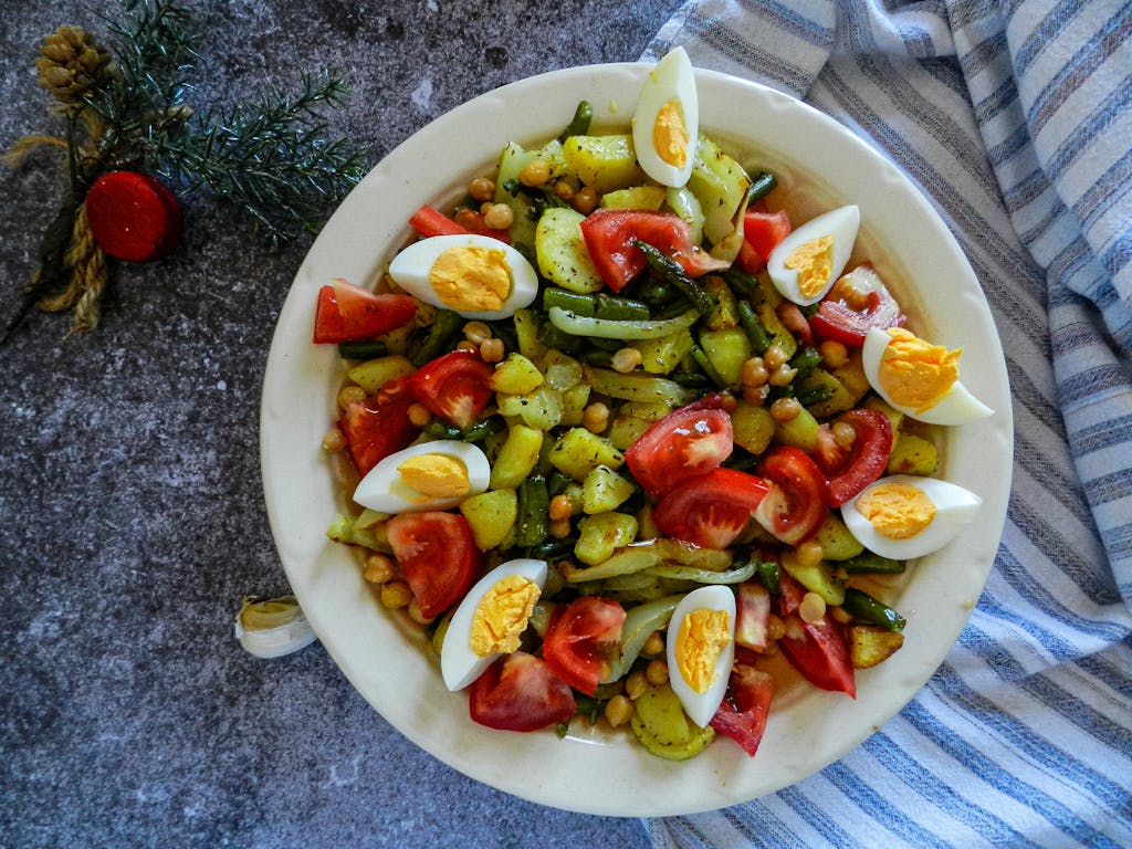 Healthy vegetable salad with chickpeas, tomatoes, and eggs, perfect for a nutritious meal.
