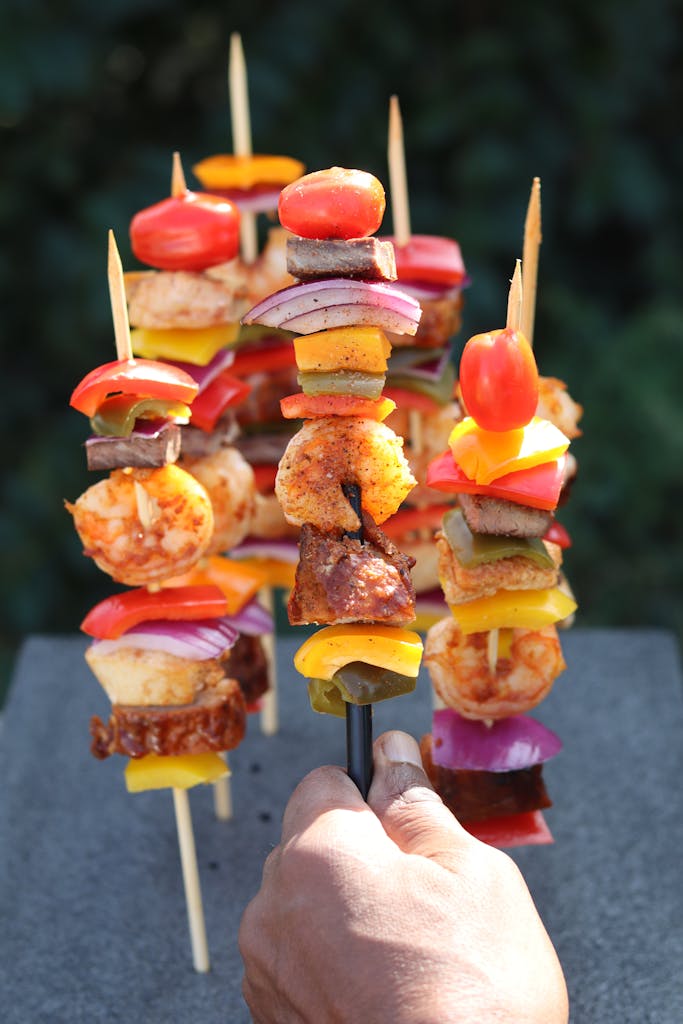 Vibrant skewers of grilled meat and veggies outdoors, perfect for BBQ themes.