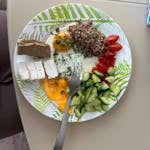 Vibrant Mediterranean breakfast with eggs, cheese, vegetables, and grains.