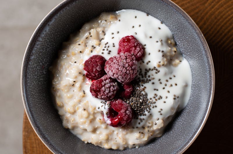 Delicious bowl of oatmeal with raspberries, yogurt, and chia seeds from above.